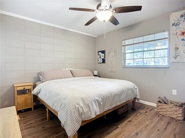 a bedroom with a bed and wooden floor