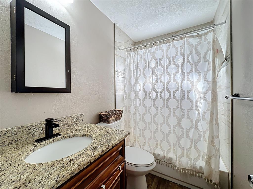 1304 Alfred Street, Unit B Brandon, FL 33510 - Photo 18 of 26 a bathroom with a granite countertop sink and a mirror