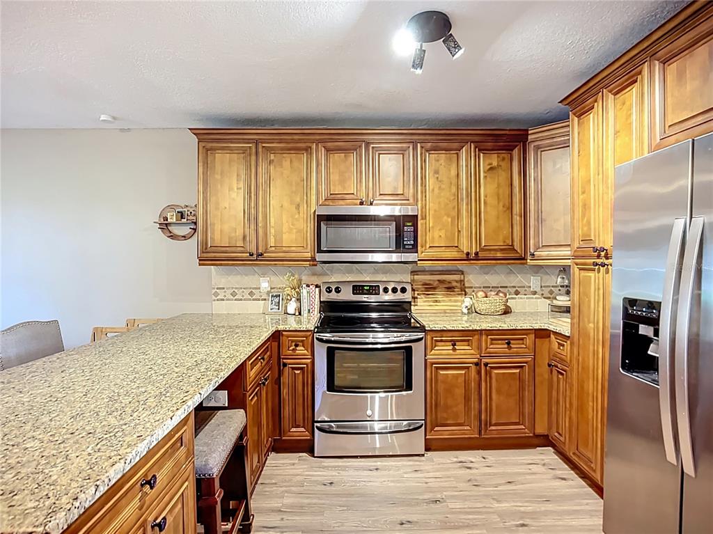 1304 Alfred Street, Unit B Brandon, FL 33510 - Photo 6 of 26 a kitchen with stainless steel appliances granite countertop a stove a refrigerator and a microwave