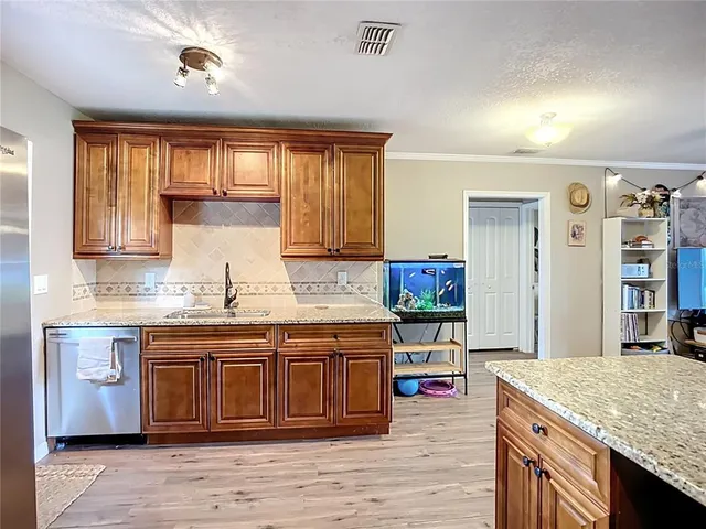 a kitchen with a stove cabinets and wooden floor