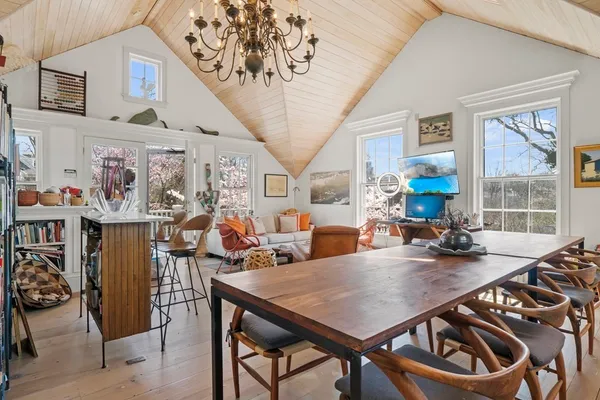 a view of a dining room with furniture a chandelier and wooden floor