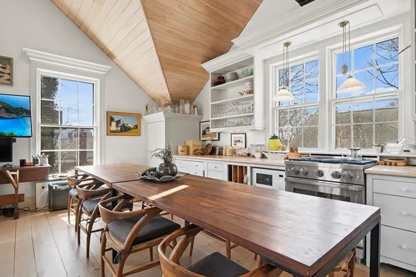a kitchen with a stove a table and chairs in it