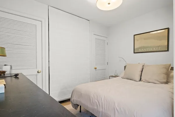 a bedroom with a bed and a painting on the wall