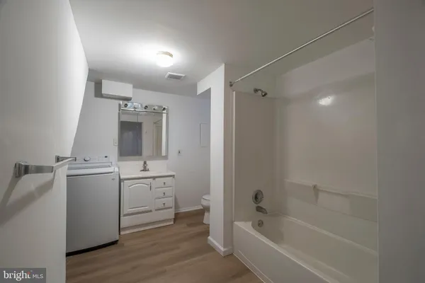 a bathroom with a tub sink and mirror