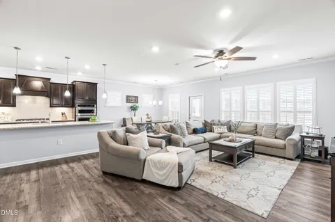 a living room with furniture kitchen view and a chandelier
