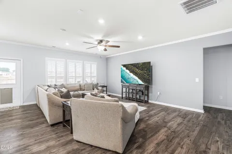 a living room with furniture kitchen view and a chandelier