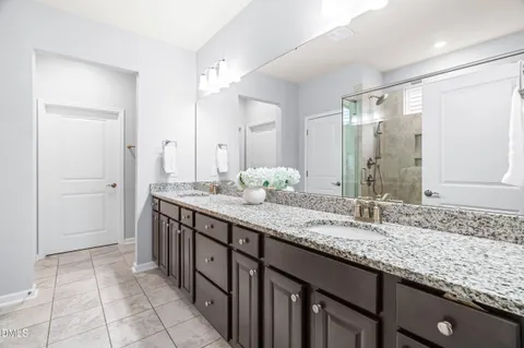 a spacious bedroom with a bed a chandelier and a large window