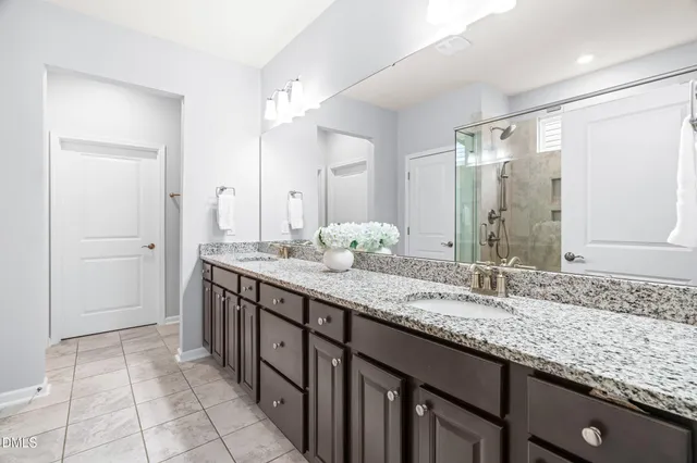 a spacious bedroom with a bed a chandelier and a large window