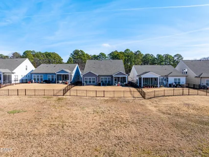 a view of house with swimming pool and yard