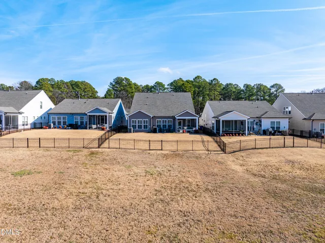 a view of house with swimming pool and yard