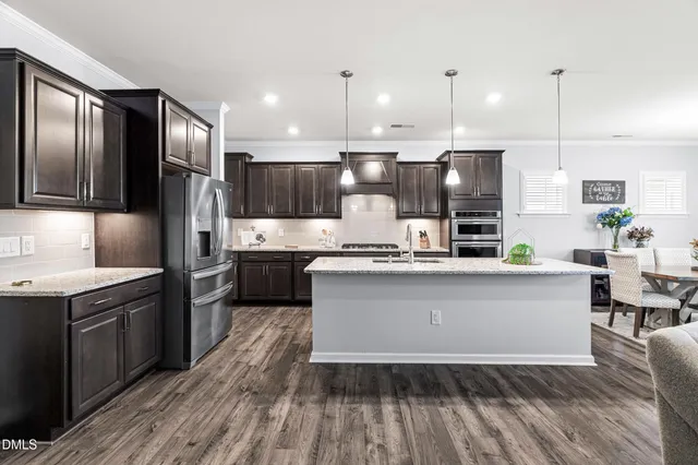 a large kitchen with stainless steel appliances kitchen island granite countertop a sink counter space and cabinets