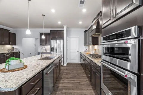 a kitchen with stainless steel appliances a refrigerator sink and stove