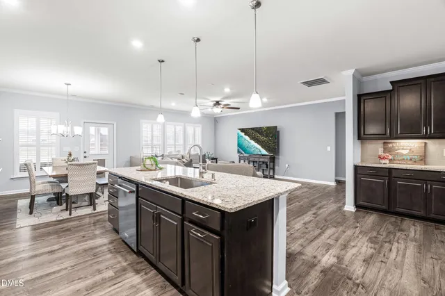 a kitchen with stainless steel appliances kitchen island granite countertop a stove and a sink