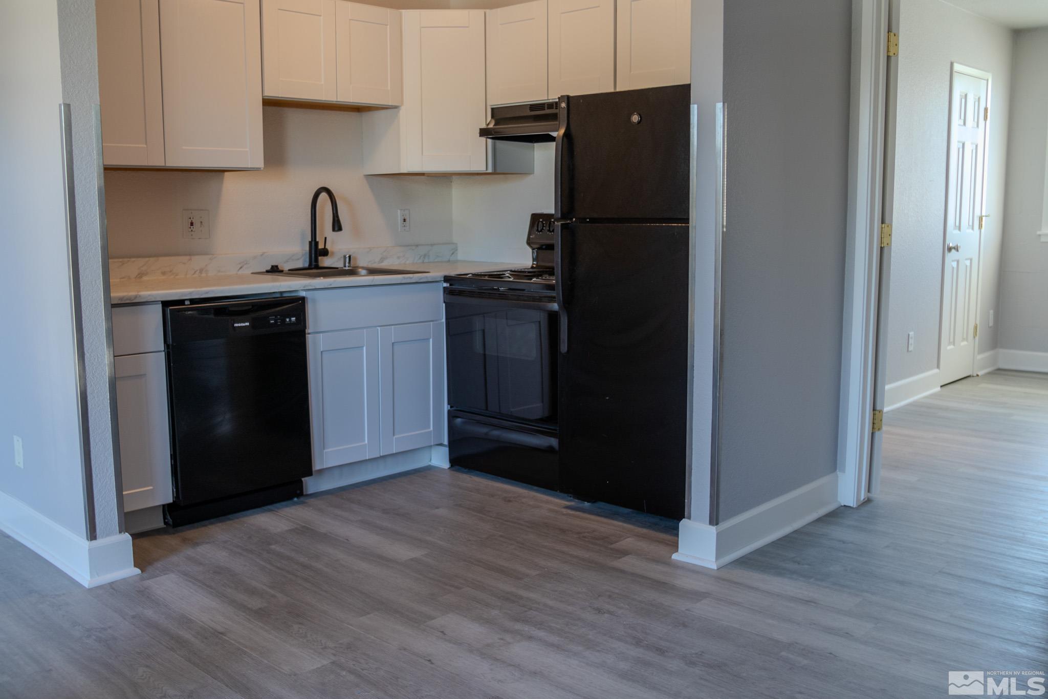 175 East Grove Street, Unit 30 Reno, NV 89502 - Photo 3 of 11 a kitchen with granite countertop white cabinets and refrigerator