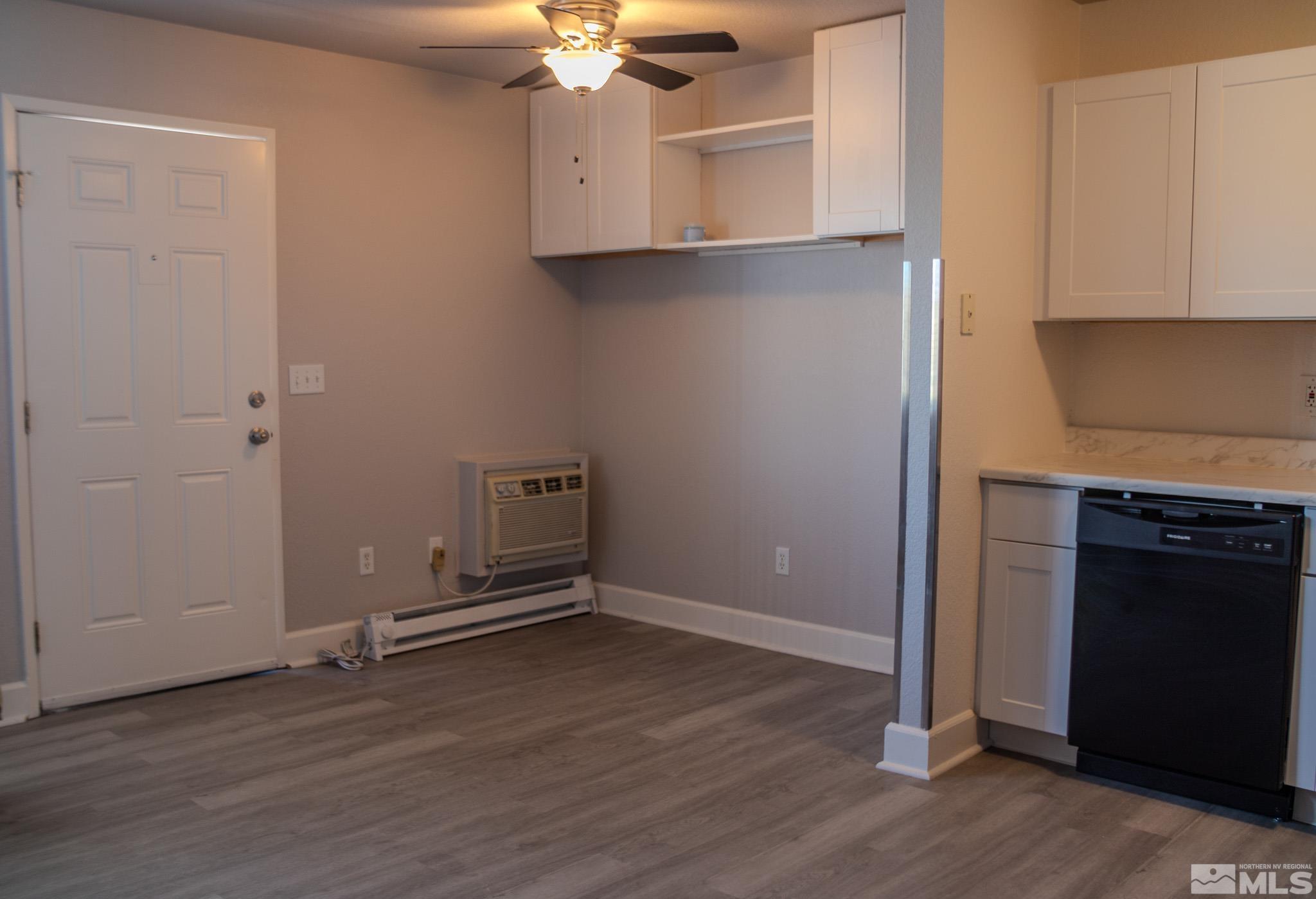 175 East Grove Street, Unit 30 Reno, NV 89502 - Photo 6 of 11 an empty room with wooden floor cabinet and a fireplace