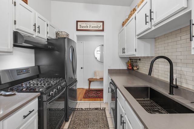 a kitchen with stainless steel appliances granite countertop a stove a sink and a refrigerator