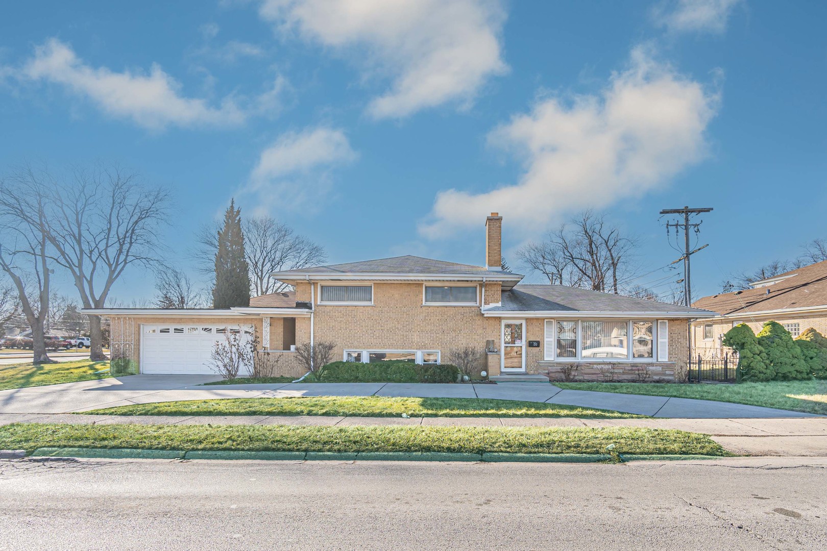 a front view of a house with a garden and yard