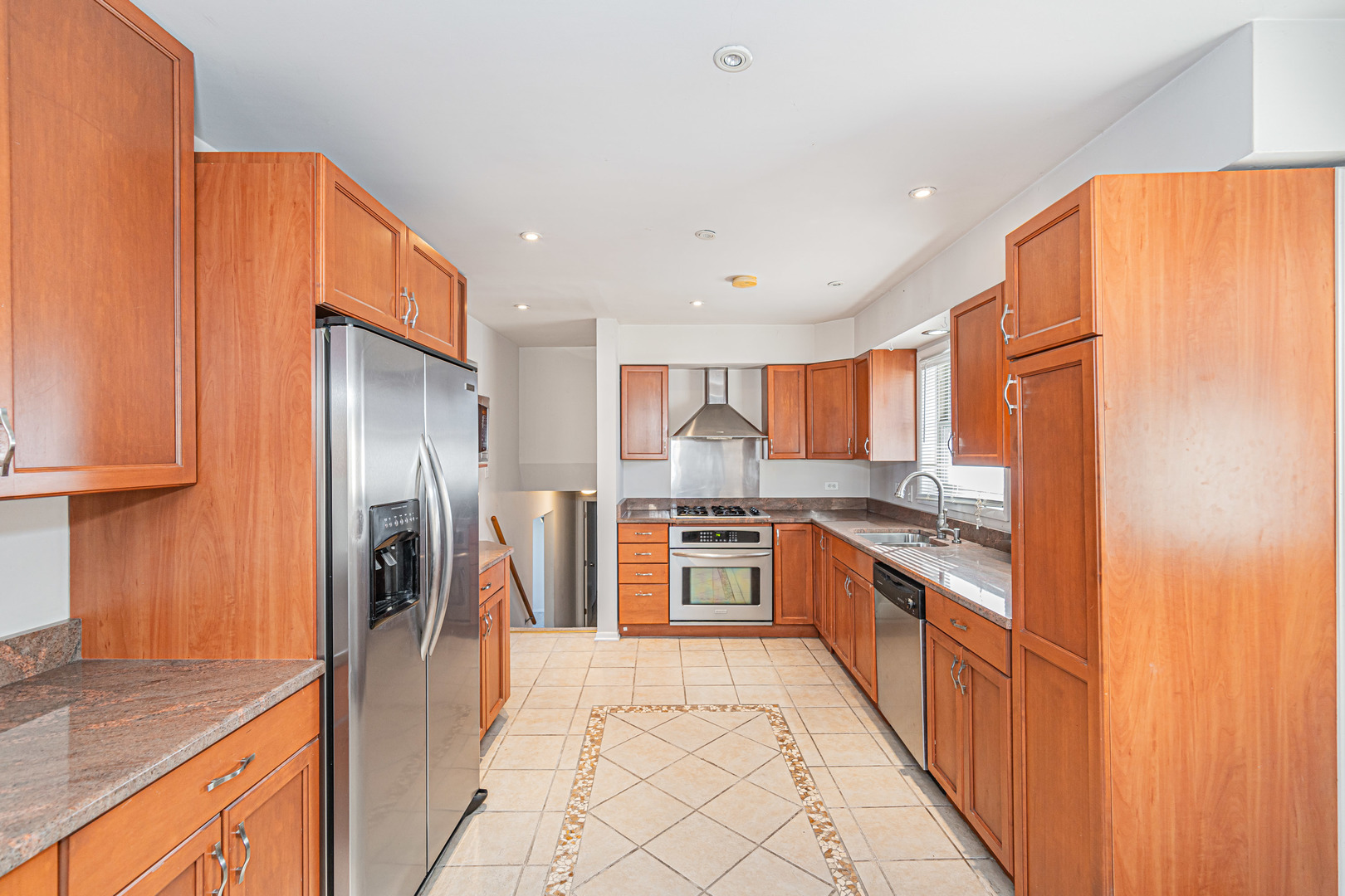 900 Devon Avenue Park Ridge, IL 60068 - Photo 6 of 30 a large kitchen with stainless steel appliances granite countertop a refrigerator a stove and a sink