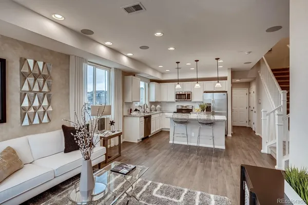 a kitchen with stainless steel appliances kitchen island granite countertop a stove a sink and a refrigerator