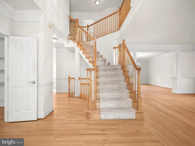 a view of an empty room with wooden floor and entryway