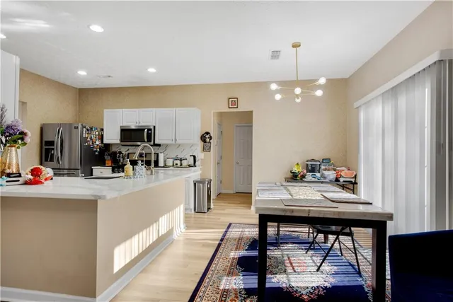 a kitchen that has a lot of cabinets a sink and appliances in it