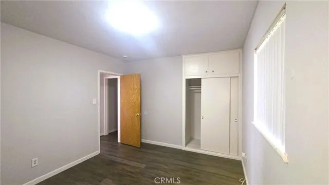 an empty room with wooden floor and closet