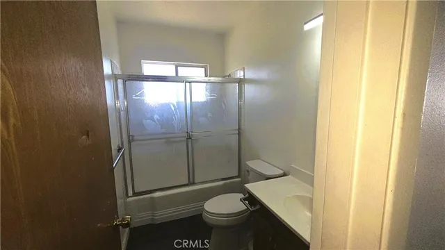a bathroom with a granite countertop toilet and a sink