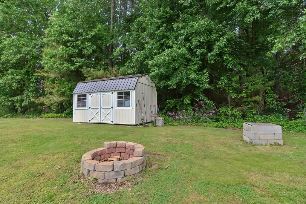 5 Salmon Brook Road Brookfield, MA 01506 - Photo 12 of 37 a backyard of a house with a garden and fire pit