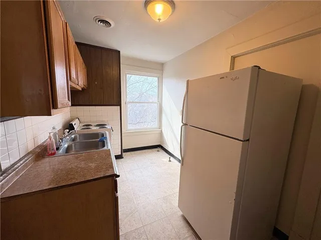 a kitchen with a refrigerator and a sink