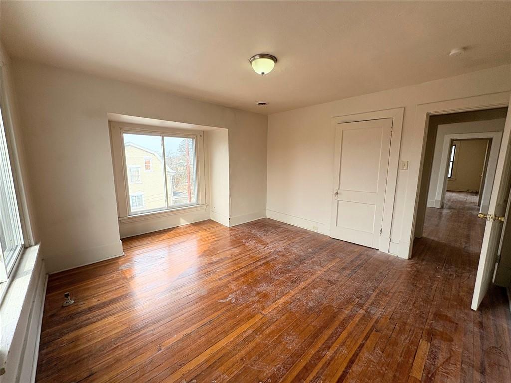 340 Rochelle Street, Unit 4 Pittsburgh, PA 15210 - Photo 4 of 6 an empty room with wooden floor and a window
