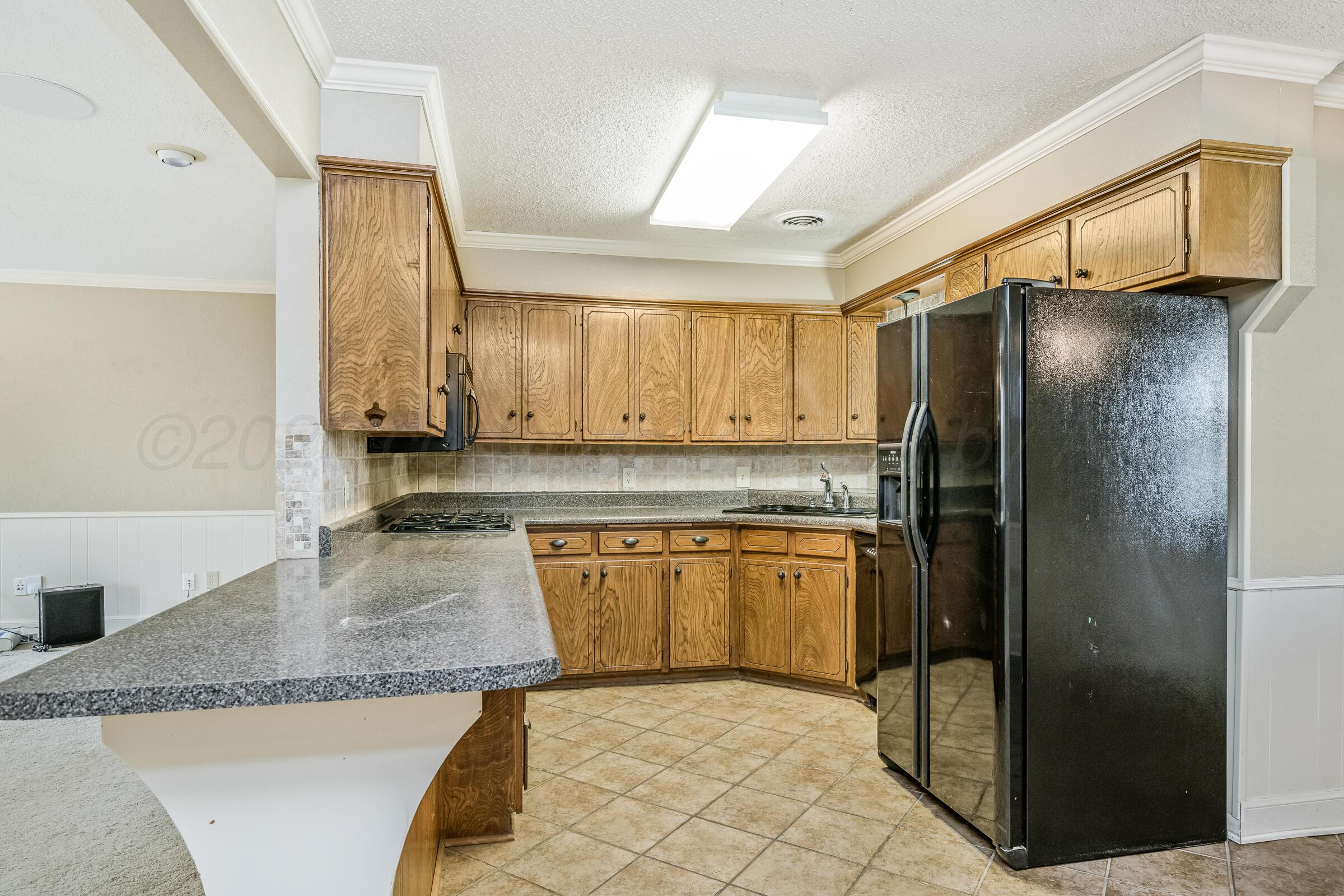 4400 West Farmers Avenue Amarillo, TX 79110 - Photo 10 of 27 a kitchen with stainless steel appliances granite countertop a sink refrigerator and cabinets