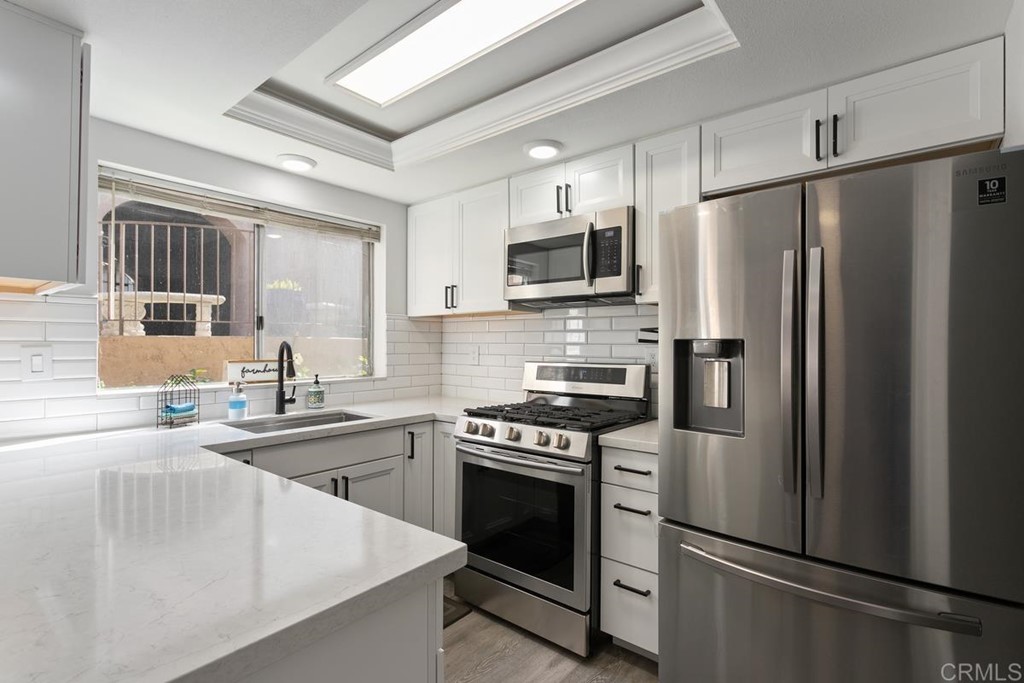 1145 Privet Street San Marcos, CA 92069 - Photo 4 of 24 a kitchen with stainless steel appliances a refrigerator sink and microwave