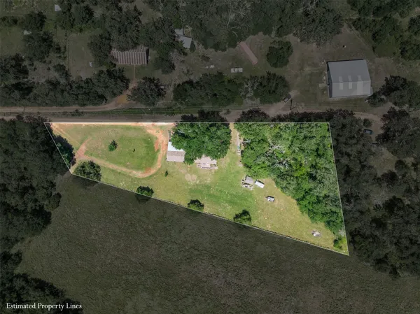 an aerial view of a house with a yard basket ball court and outdoor seating