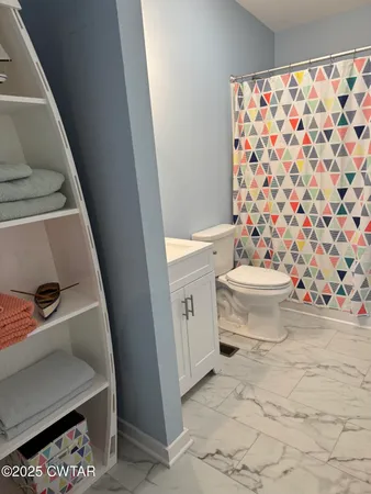 a bathroom with a toilet and a shower curtain