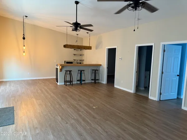 a view of a kitchen with a wooden floor and a ceiling fan