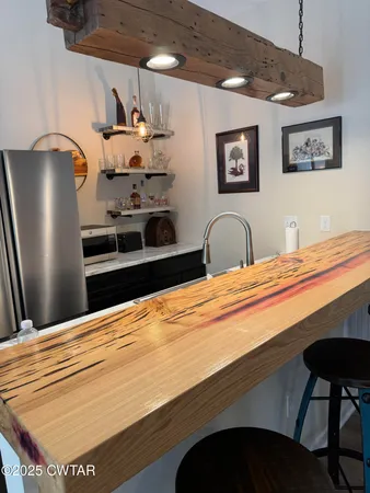 a kitchen with stainless steel appliances granite countertop a sink dishwasher and a refrigerator with wooden floor