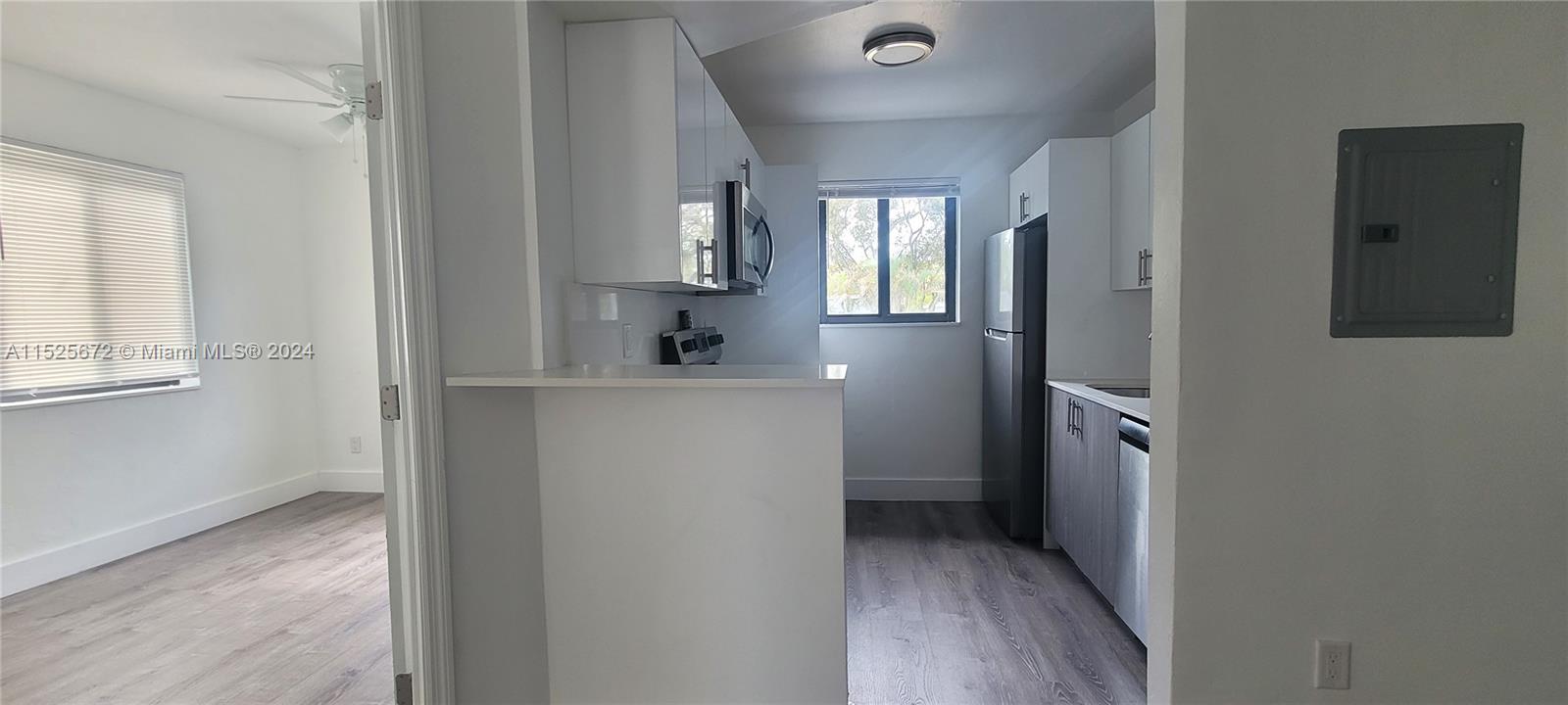 hallway with wooden floor and cabinets