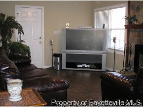 6435 Applewhite Road Fayetteville, NC 28304 - Photo 5 of 10 a living room with furniture a flat screen tv and a fireplace