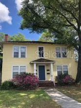 a front view of a house with a garden and plants