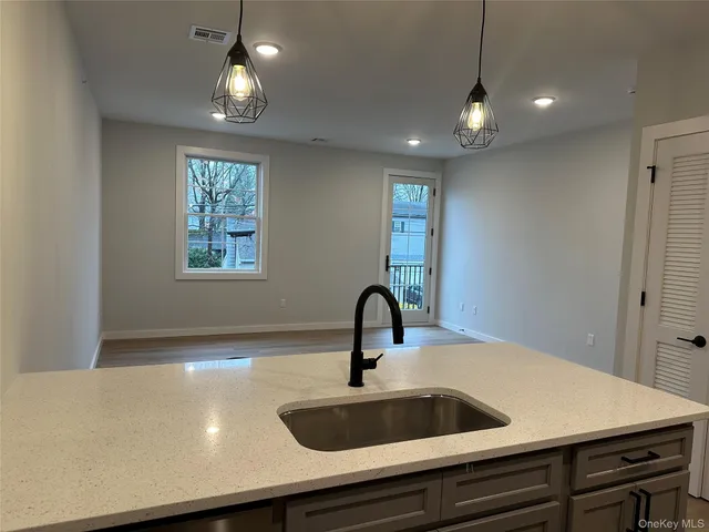 a view of a sink a counter space and a window in a room