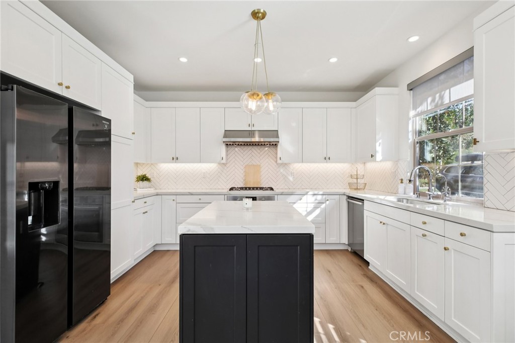 151 Soaring Eagle Irvine, CA 92618 - Photo 15 of 57 a kitchen with kitchen island granite countertop a sink appliances cabinets and a counter top space