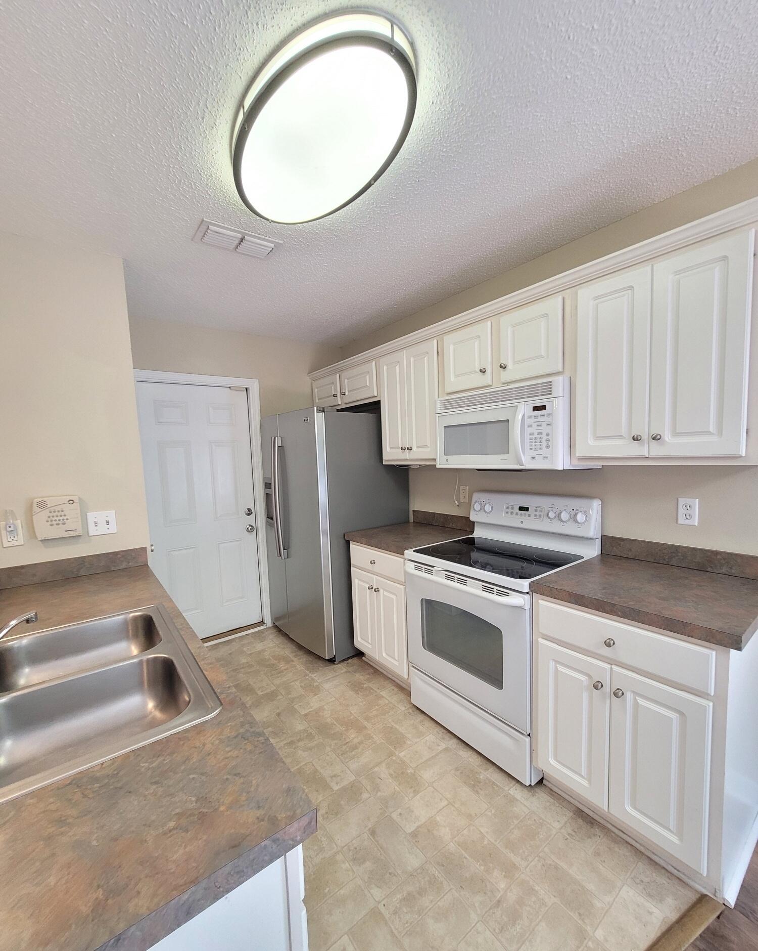 268 Limestone Circle Crestview, FL 32539 - Photo 11 of 23 a kitchen with white cabinets and white appliances