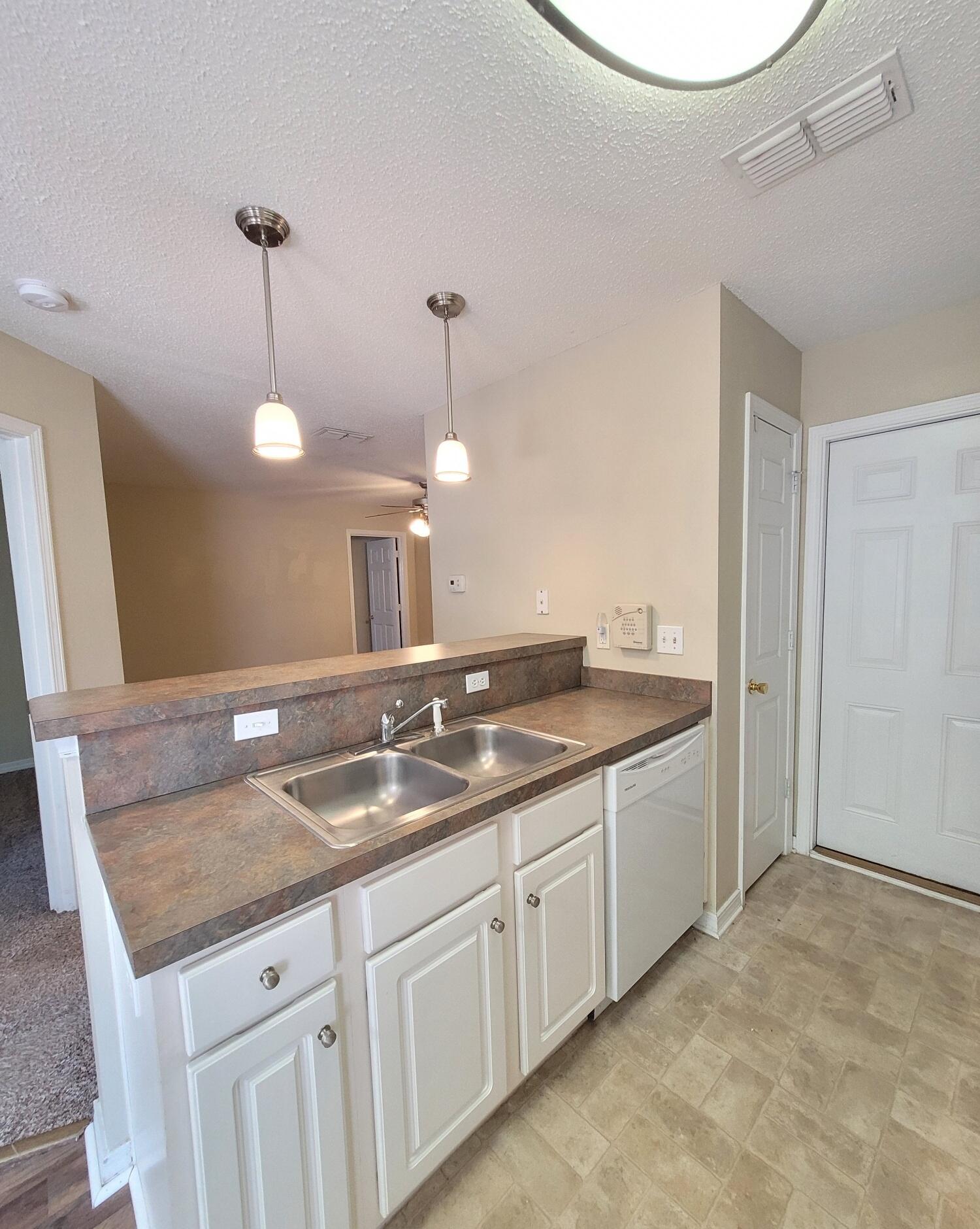 268 Limestone Circle Crestview, FL 32539 - Photo 12 of 23 a kitchen with a sink and a refrigerator