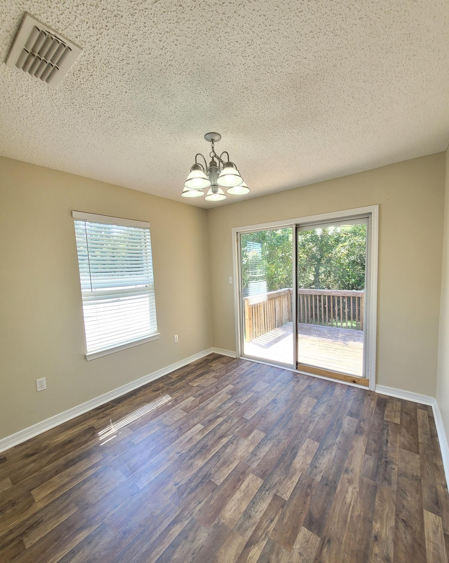 268 Limestone Circle Crestview, FL 32539 - Photo 8 of 23 a view of an empty room with wooden floor and a window