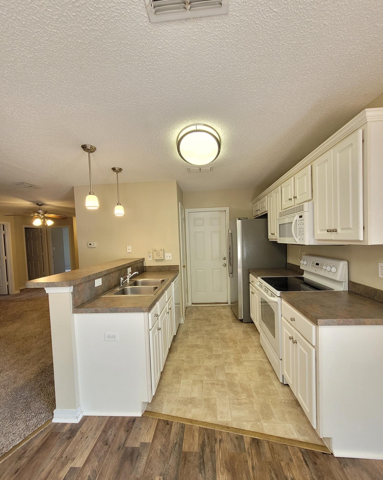268 Limestone Circle Crestview, FL 32539 - Photo 9 of 23 a kitchen with stainless steel appliances granite countertop a stove a sink and a refrigerator