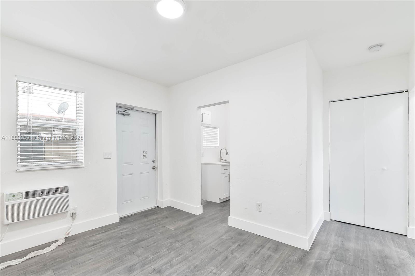212 Northwest 15th Street, Unit 2 Miami, FL 33136 - Photo 13 of 19 a view of an empty room with wooden floor and a window