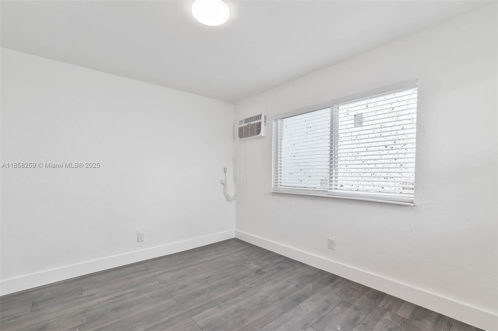 212 Northwest 15th Street, Unit 2 Miami, FL 33136 - Photo 18 of 19 an empty room with wooden floor and windows