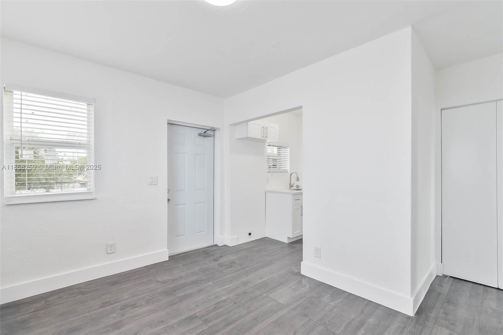 212 Northwest 15th Street, Unit 2 Miami, FL 33136 - Photo 19 of 19 a view of an empty room with wooden floor and a window
