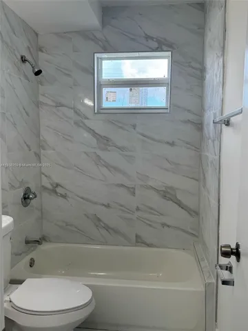 a bathroom with a toilet and a bathtub