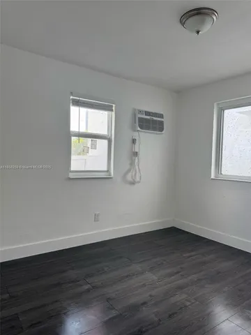 a view of a room that has wooden floor and windows